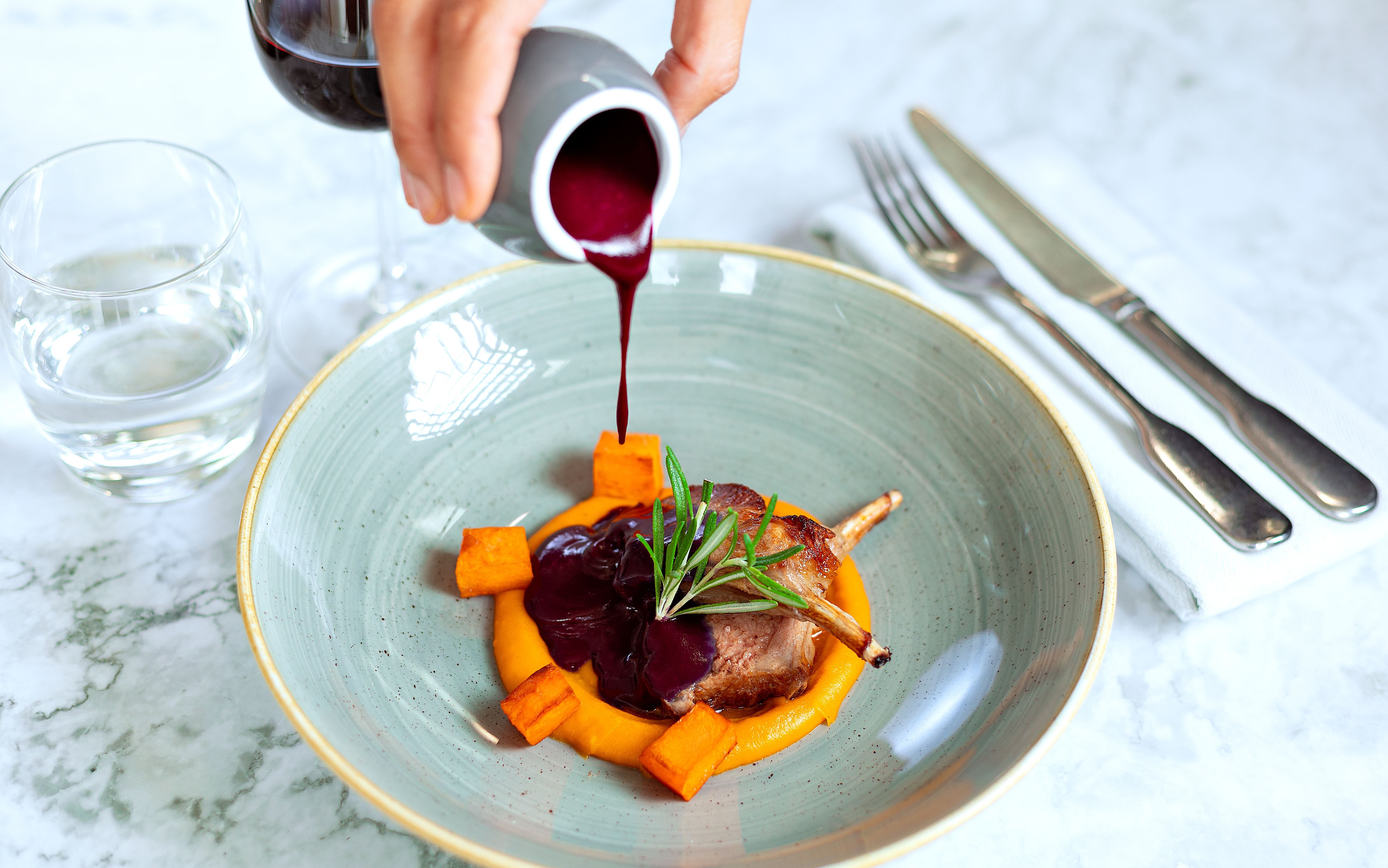 Lamb dish with sauce being poured, served on Bustronome London tour.