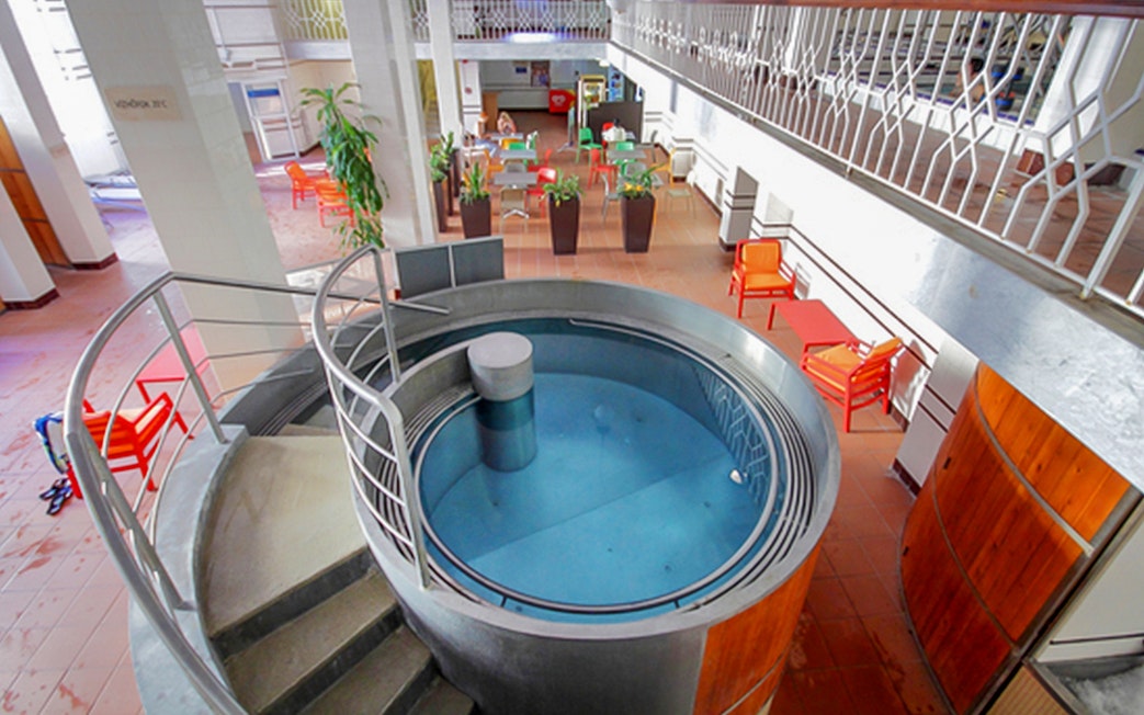 Indoor pool area with seating at Lukacs Spa, Budapest.
