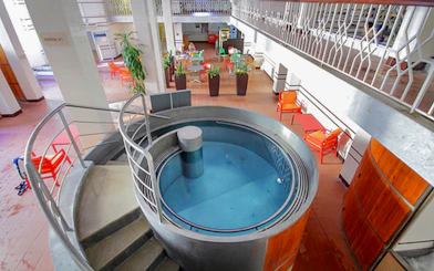 Indoor pool area with seating at Lukacs Spa, Budapest.