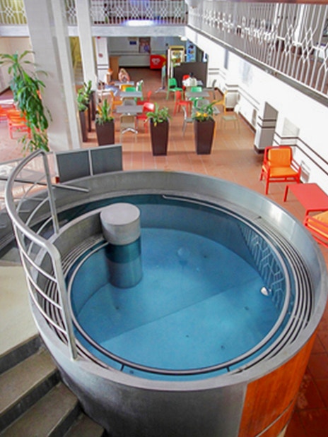 Indoor pool area with seating at Lukacs Spa, Budapest.