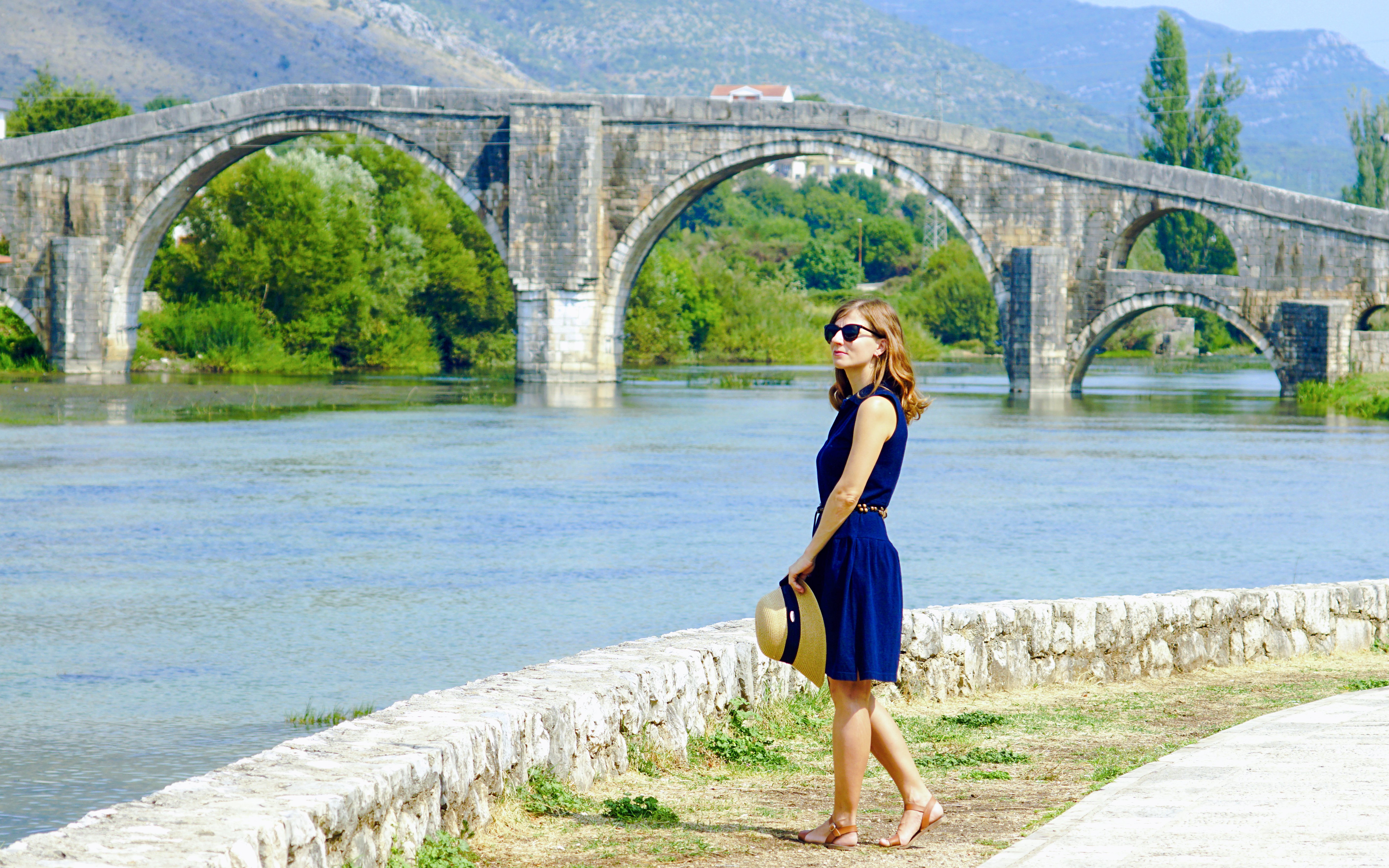 Tourist standing by the Arslanagic Bridge in Trebinje, Bosnia and Herzegovina.