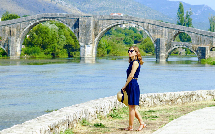 Tourist standing by the Arslanagic Bridge in Trebinje, Bosnia and Herzegovina.