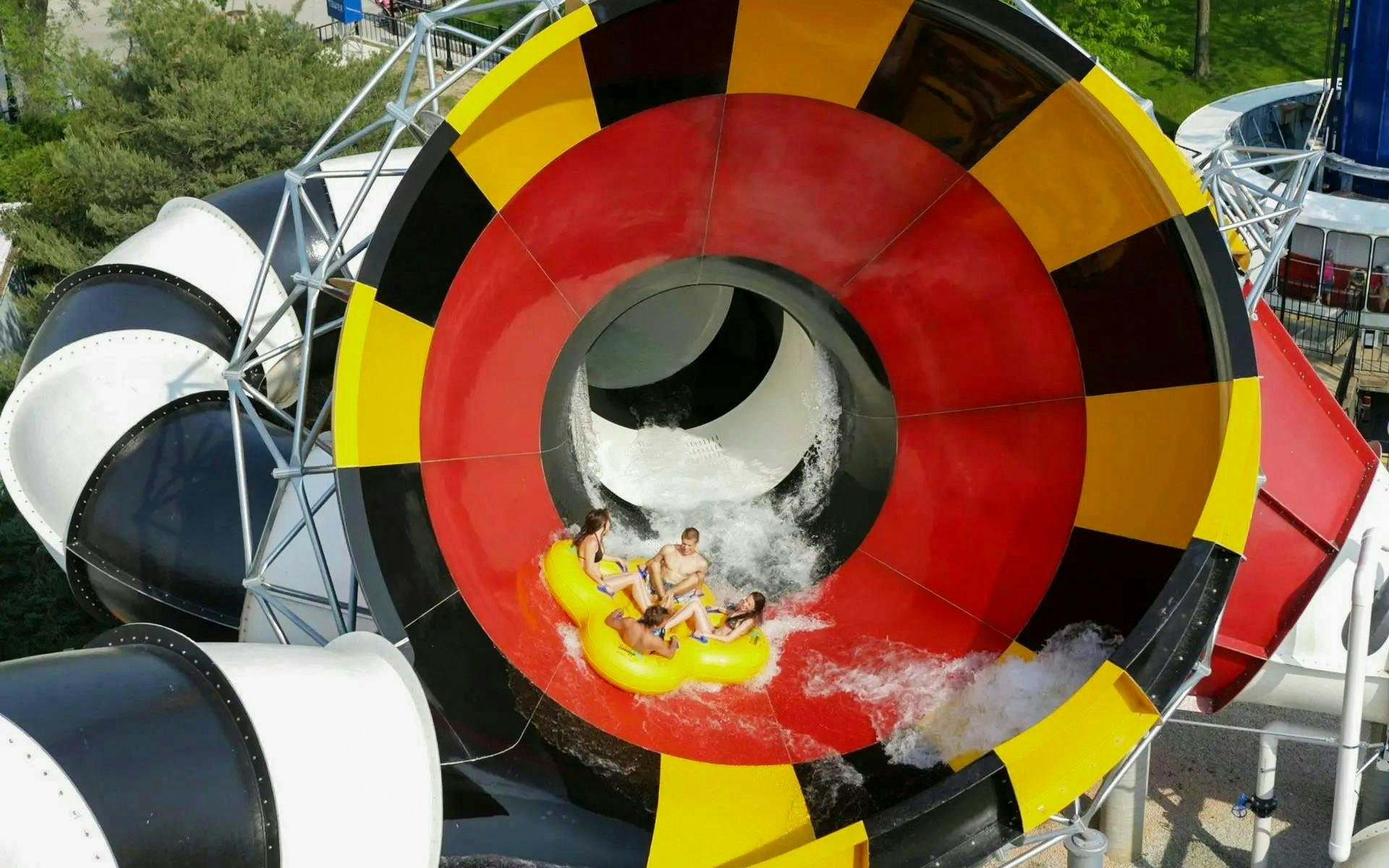 Water slide at Hurricane Harbor Chicago with people on a yellow raft.
