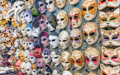 Venetian carnival masks displayed on a wall in Venice, Italy.