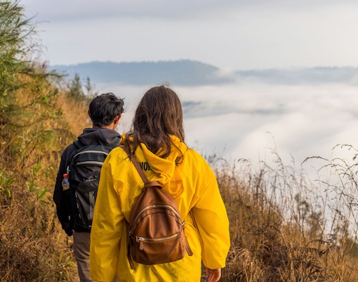 Hikers walking along a trail with misty views at Mount Batur.