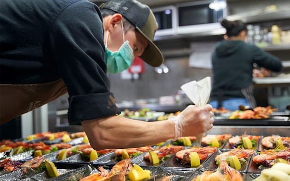 Chef preparing seafood dishes at Spirit of Melbourne Cruising Restaurant.