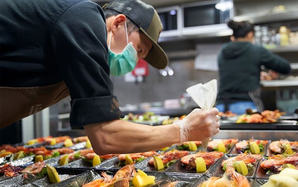 Chef preparing seafood dishes at Spirit of Melbourne Cruising Restaurant.