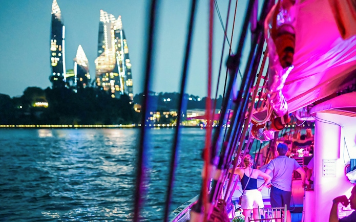 Sailing on the Royal Albatross with city skyline and coastline views.