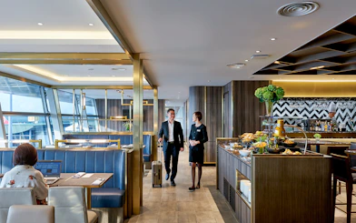 Plaza Premium Lounge at Langkawi Airport with guests and buffet area.