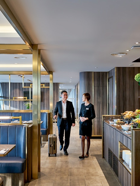 Plaza Premium Lounge at Langkawi Airport with guests and buffet area.