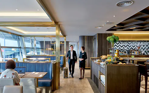 Plaza Premium Lounge at Langkawi Airport with guests and buffet area.