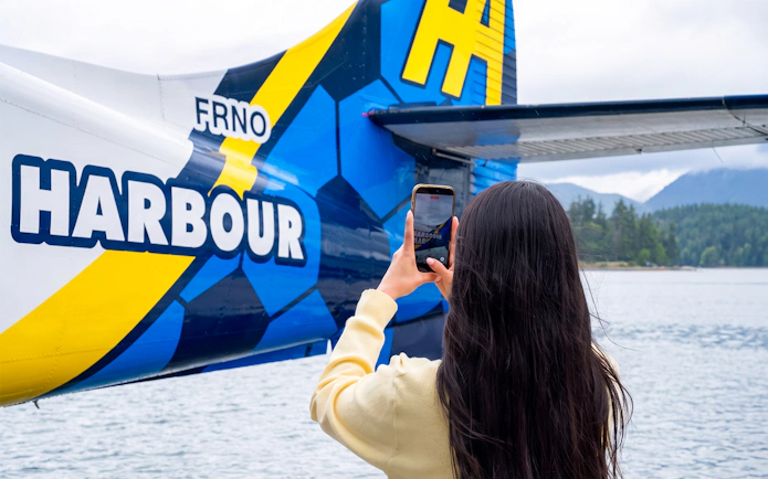 Woman photographing seaplane tail during Vancouver Panorama Scenic Seaplane Tour.