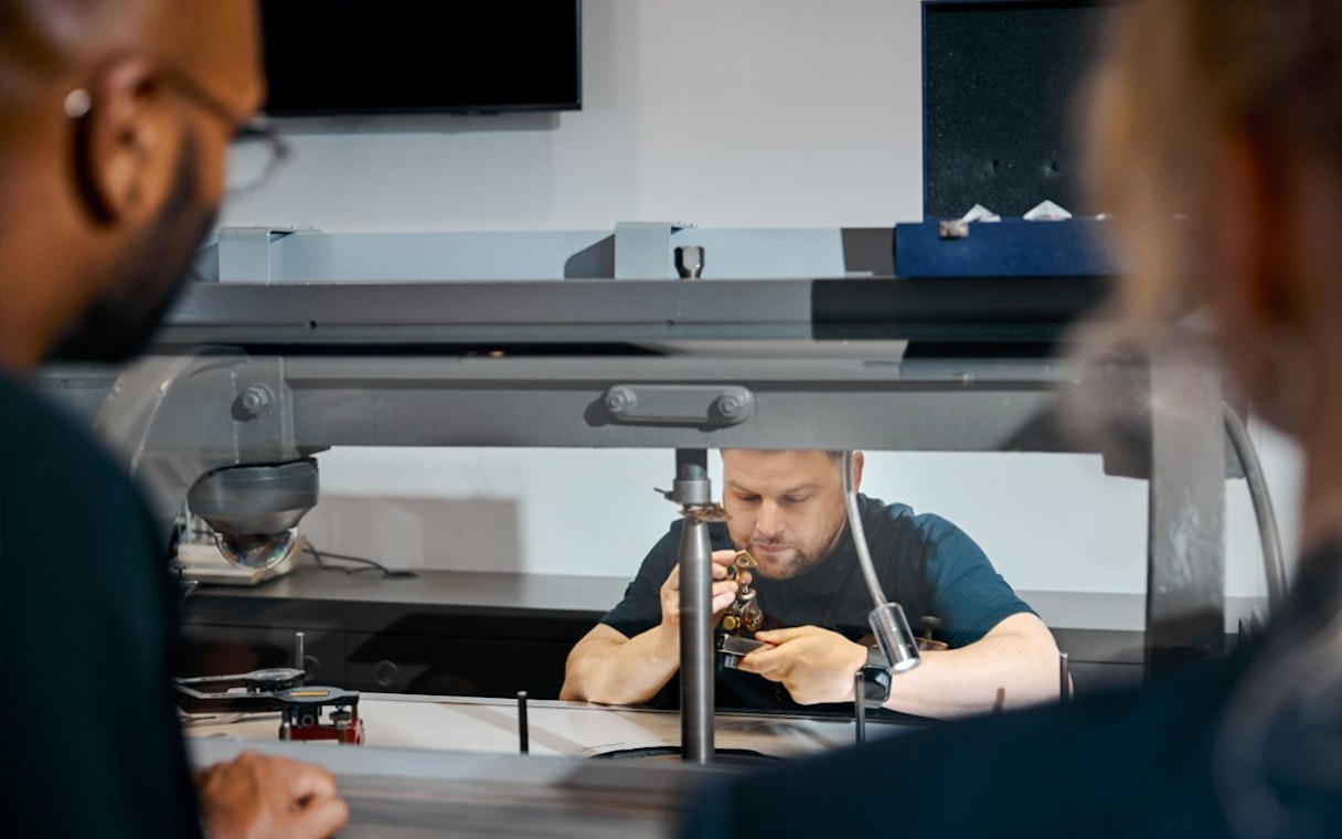 Guests watching a craftsman polishing diamonds at Royal Coster Diamond Experience, Amsterdam.