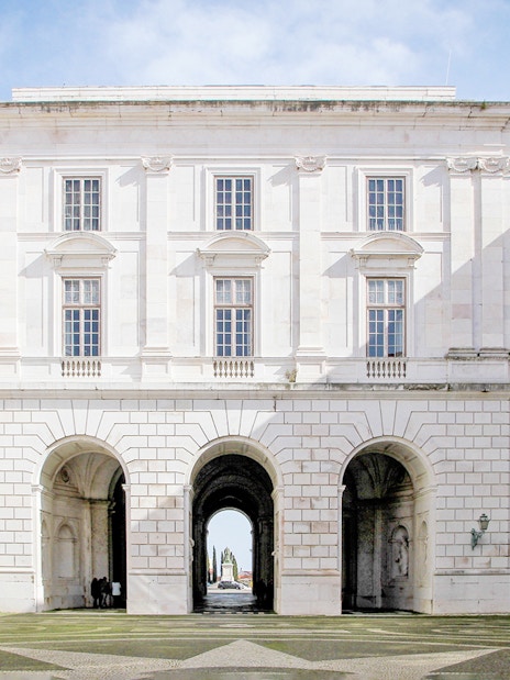 Courtyard of National Palace of Ajuda, Lisbon with arched entrance and visitors.