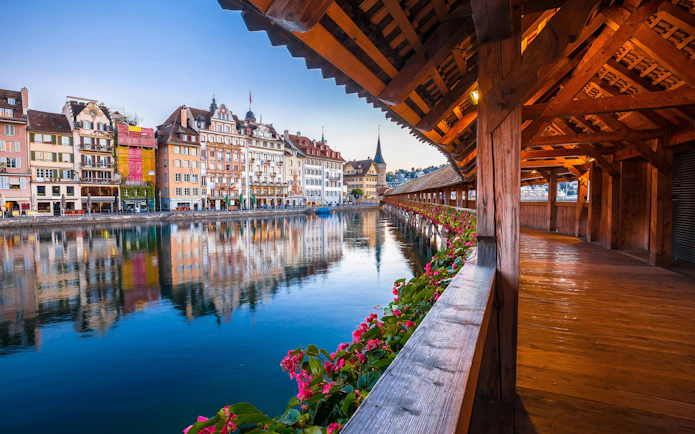 Kapellbrucke wooden bridge and waterfront buildings at dawn in Luzern, Switzerland.