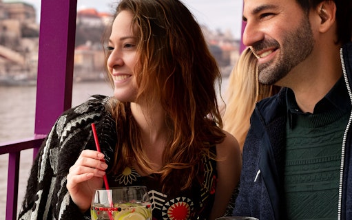 Couple enjoying drinks on a Budapest cocktail cruise.
