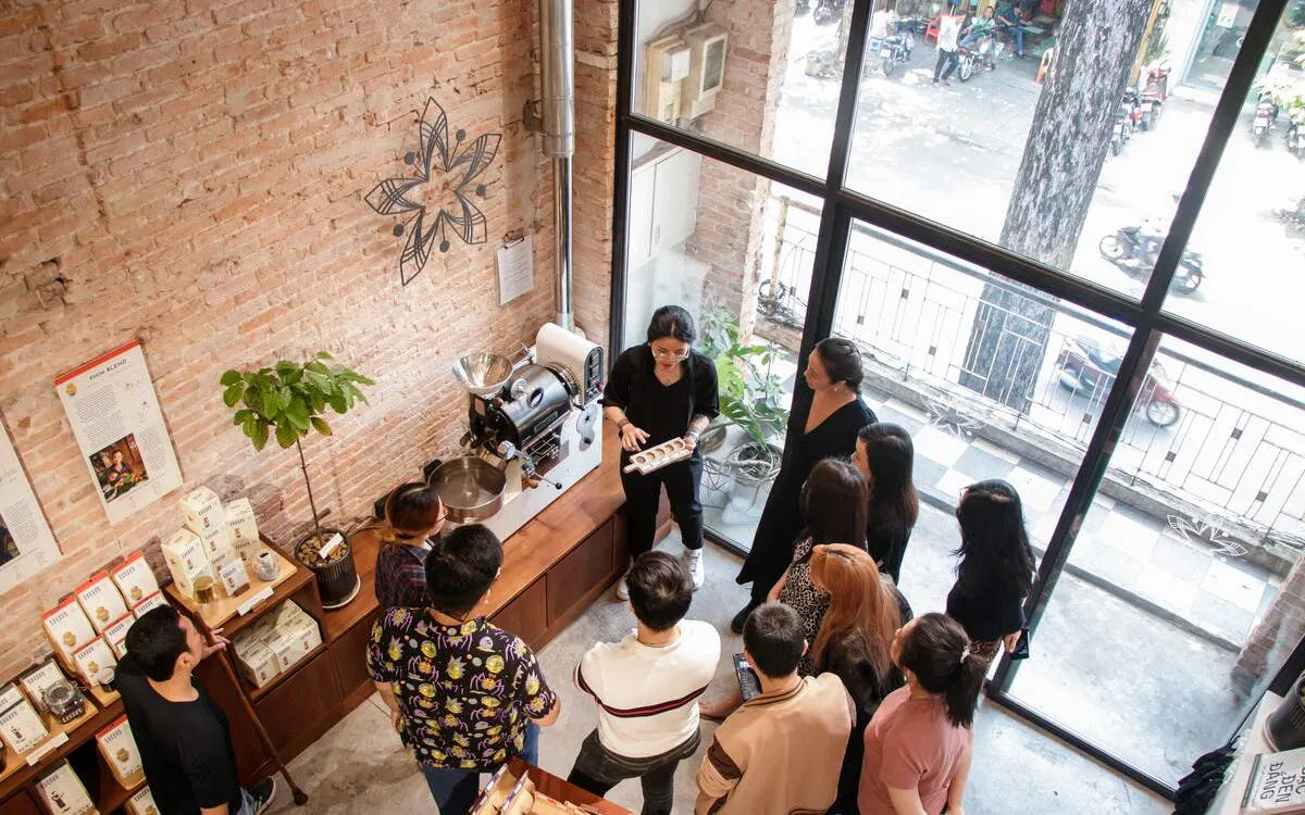 Group learning about Vietnamese coffee brewing in a Ho Chi Minh City café.