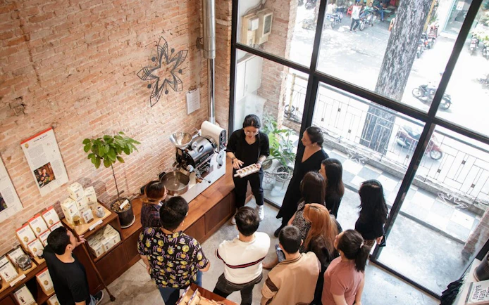 Group learning about Vietnamese coffee brewing in a Ho Chi Minh City café.