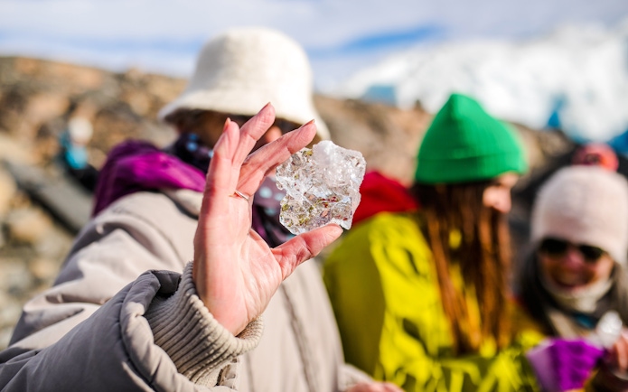 Guest holding ice block on Perito Moreno glacier tour in Argentina.