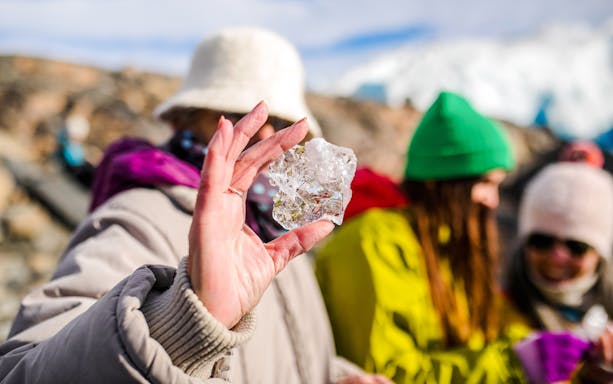 Guest holding ice block on Perito Moreno glacier tour in Argentina.