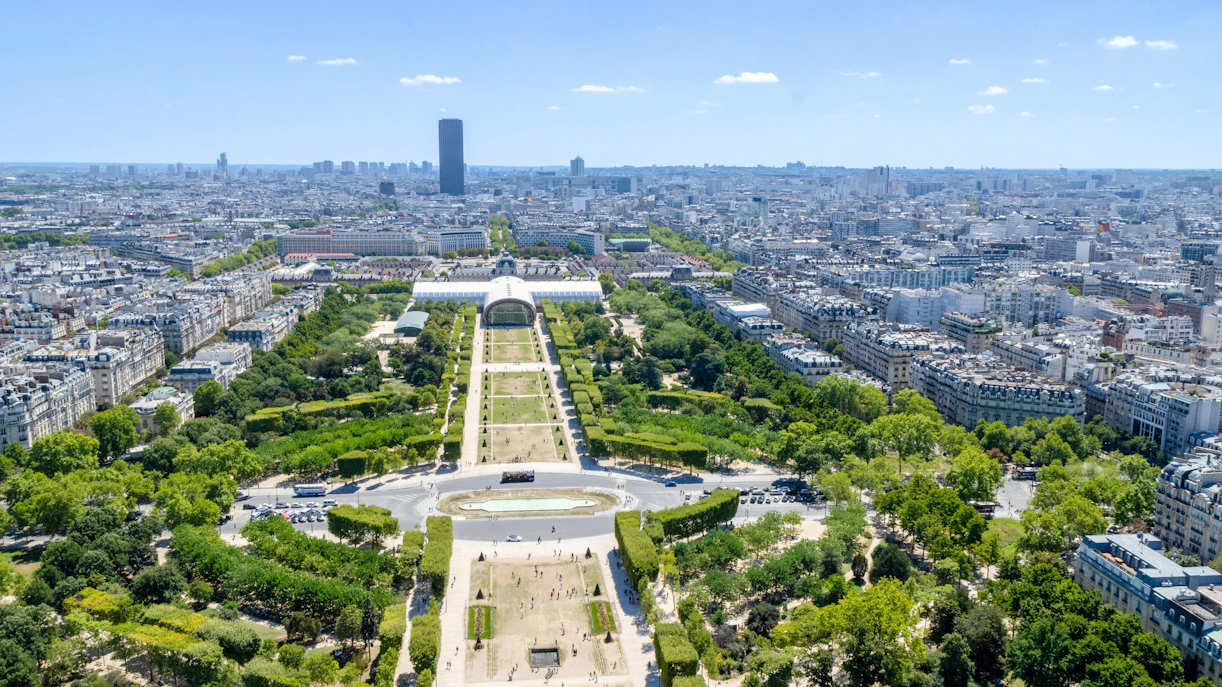 Aerial view of Champ de Mars park in Paris with cityscape in the background.