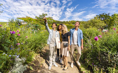 Visitors exploring Giverny Garden with a guide pointing out features.