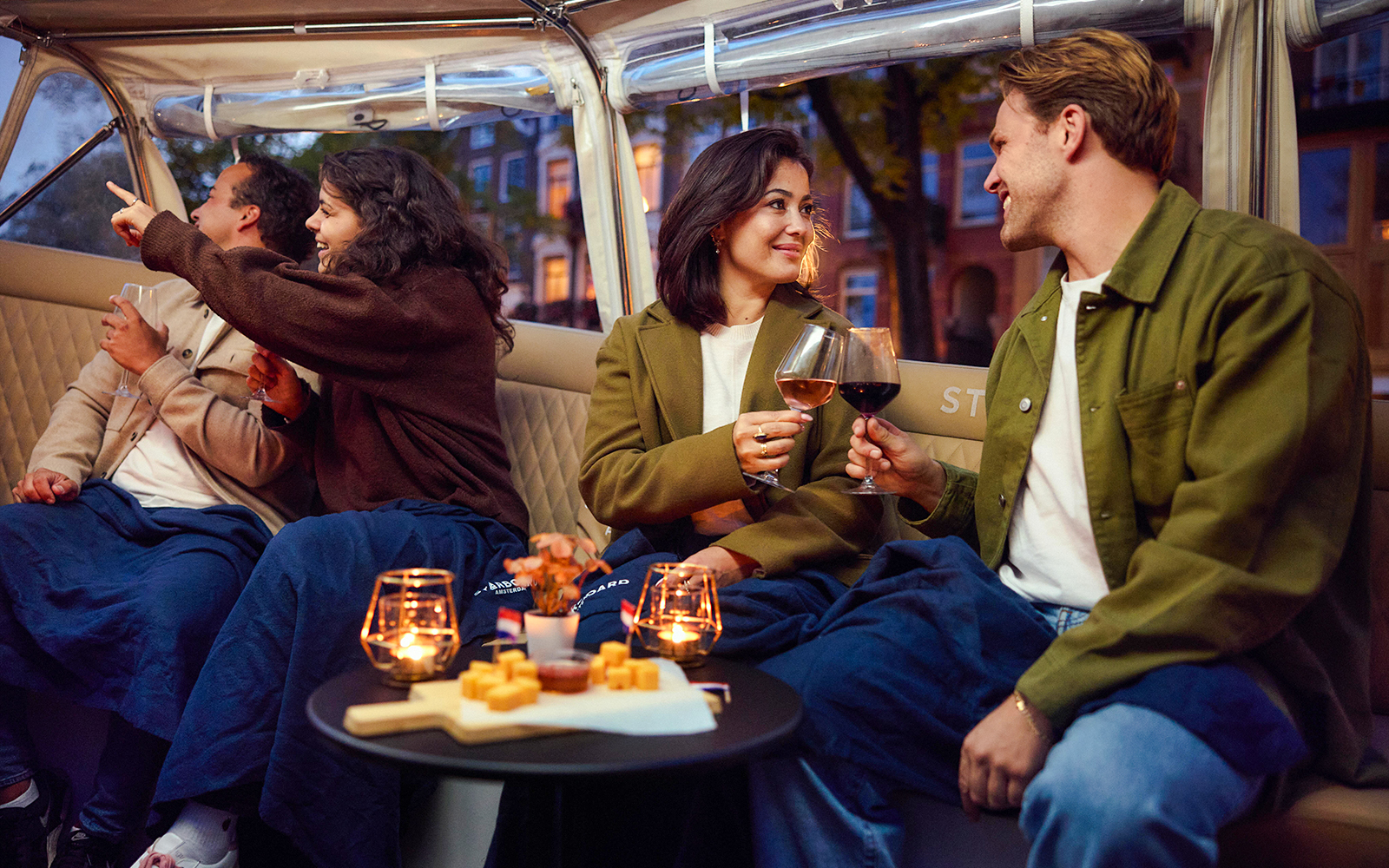 Guests enjoying wine and cheese on an evening candlelight cruise.