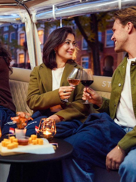 Guests enjoying wine and cheese on an evening candlelight cruise.