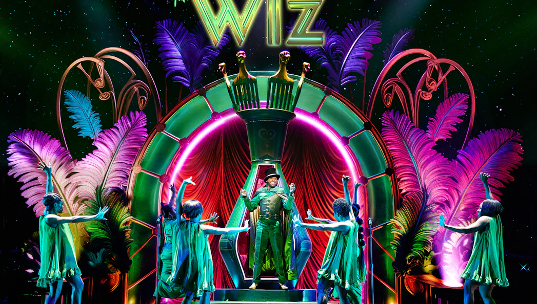 Stage performance of "The Wiz" with vibrant costumes and colorful set design.
