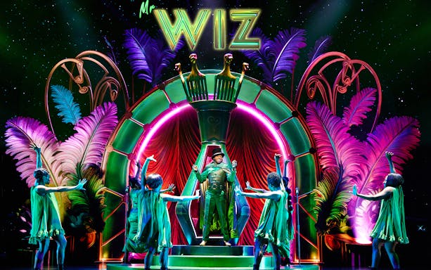 Stage performance of "The Wiz" with vibrant costumes and colorful set design.