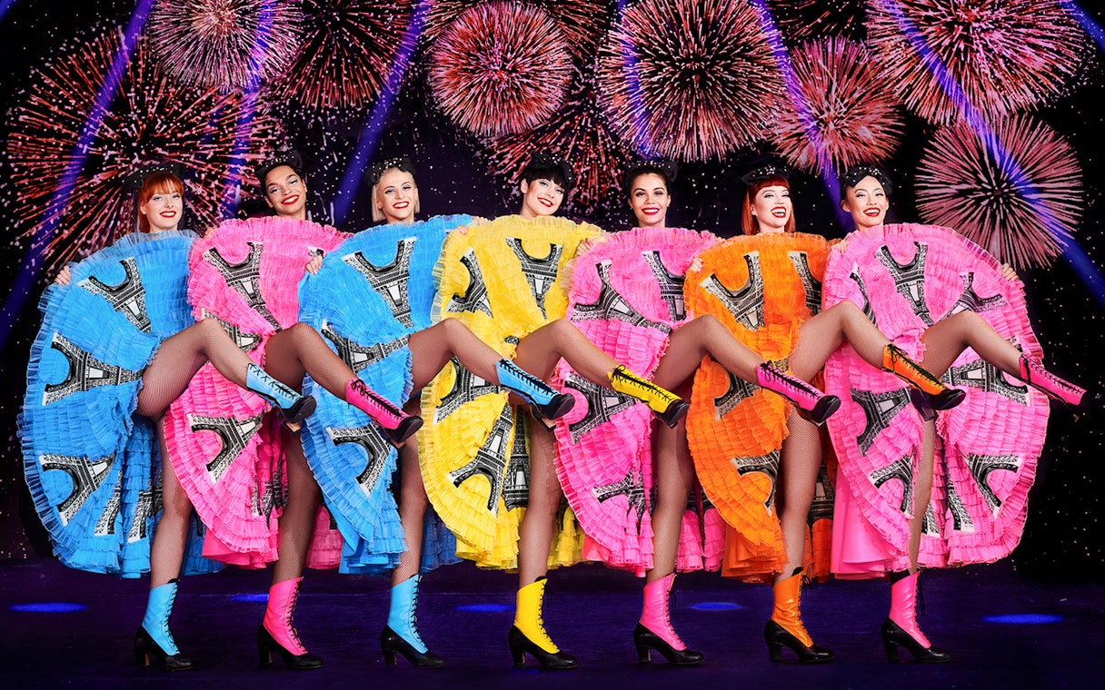 Cabaret dancers performing at New Year's Eve dinner party in Paris with fireworks.