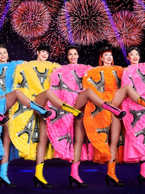 Cabaret dancers performing at New Year's Eve dinner party in Paris with fireworks.