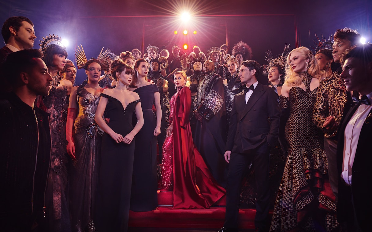 Stage performance of The Devil Wears Prada West End show with cast in elaborate costumes.