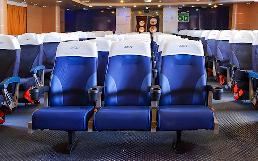 Comfortable seating on SNAV Ferry with blue and white chairs in a spacious cabin.