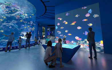 Colourful fishes in large tank at Singapore Oceanarium with visitors observing.