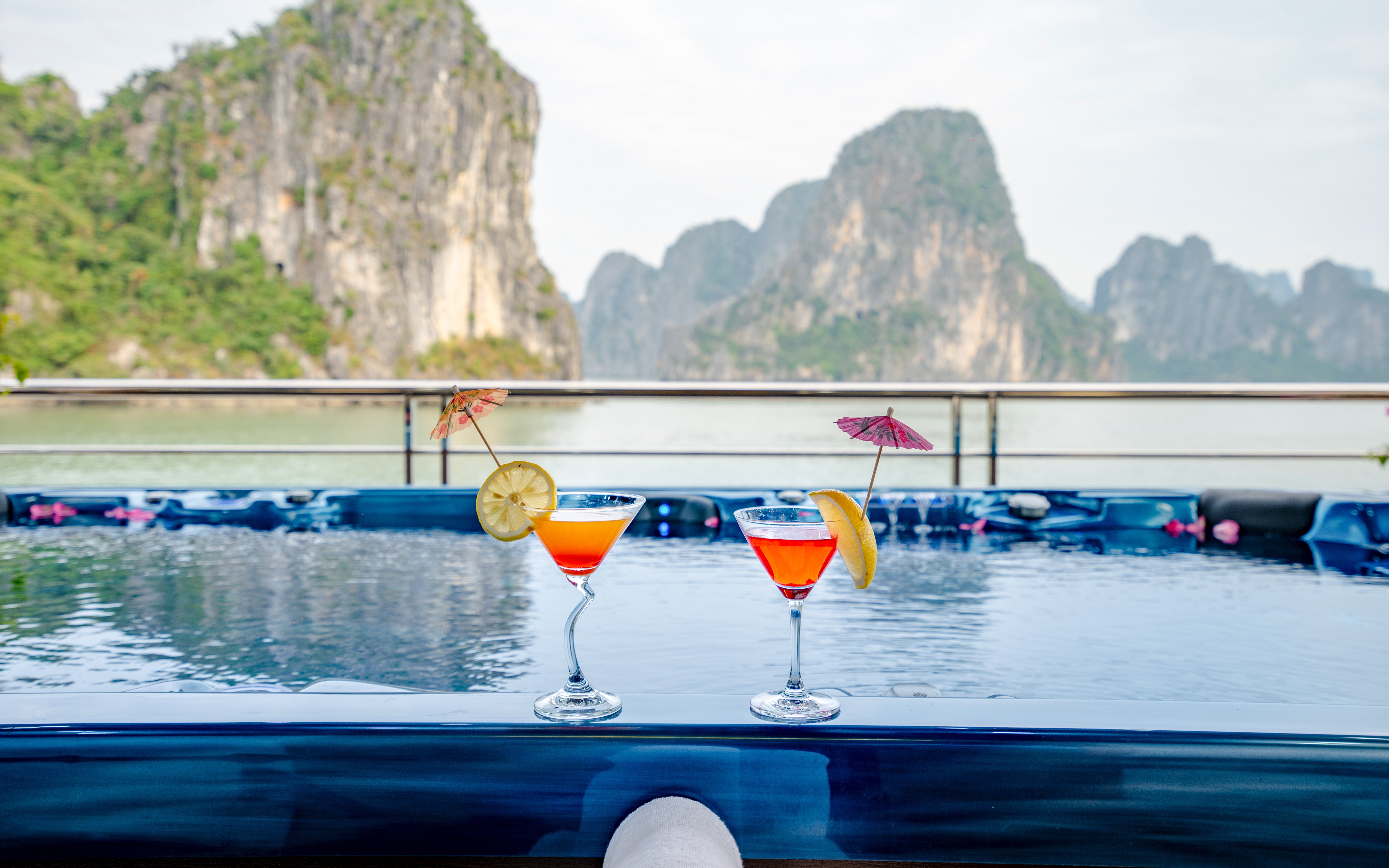 Jacuzzi with cocktails on Phong Hai Harmony Cruise, Halong Bay backdrop.