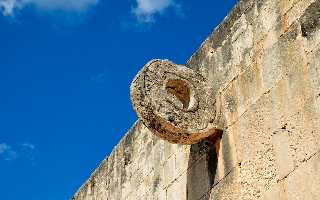 Chichen Itza Ball Court stone ring against a blue sky.