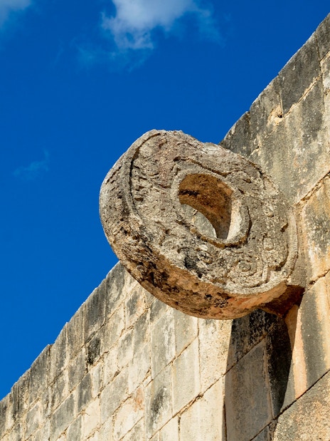 Chichen Itza Ball Court stone ring against a blue sky.