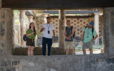 Tourists exploring ancient ruins on a guided tour in Pompeii, Italy.