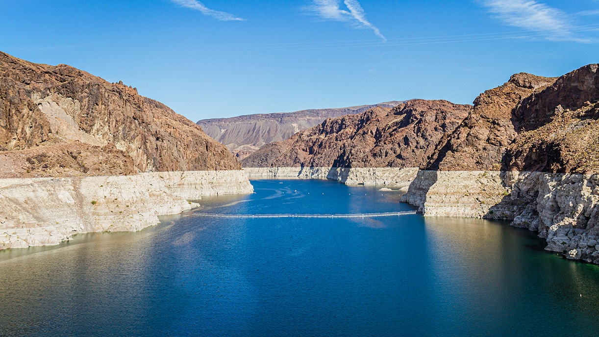 Lake Mead surrounded by rocky cliffs under a clear blue sky.