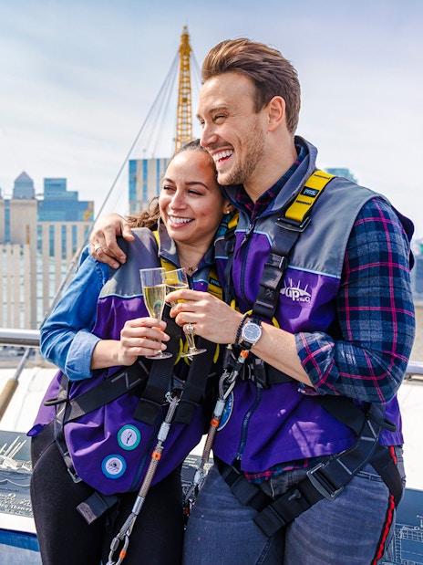 Guests enjoying drinks on Up at the O2 Celebration Climb with London skyline in background.