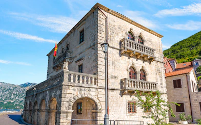 Historic stone building of the Museum of Perast city with arched windows and balconies.