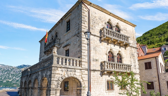 Historic stone building of the Museum of Perast city with arched windows and balconies.