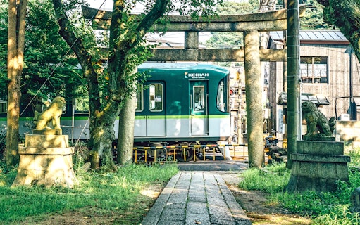 Keihan Railway train passing through a torii gate on the Otsu Line in Japan.