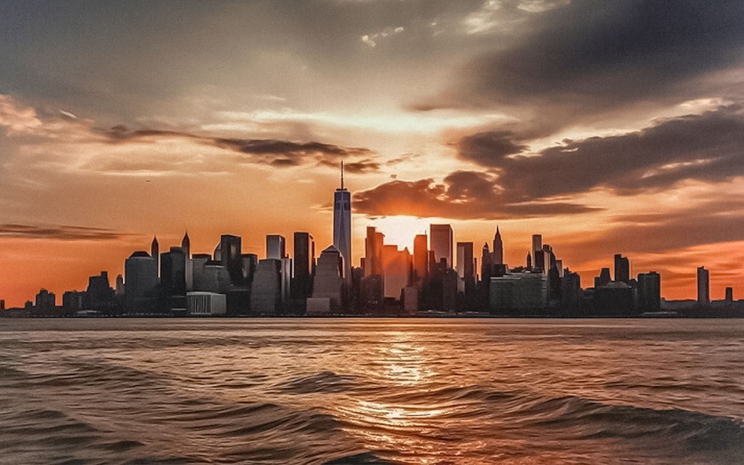 New York City skyline at sunset from Ellis Island cruise.