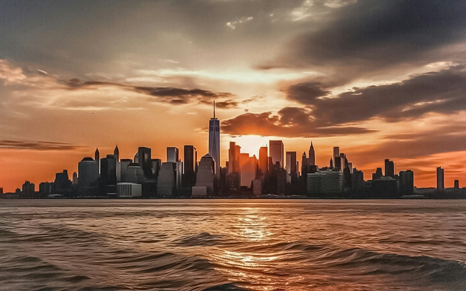 Statue of Liberty and Ellis Island at sunset during a scenic cruise in New York City.