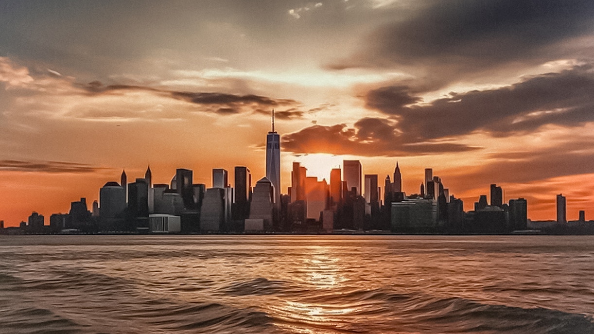 New York City skyline at sunset from Ellis Island cruise.