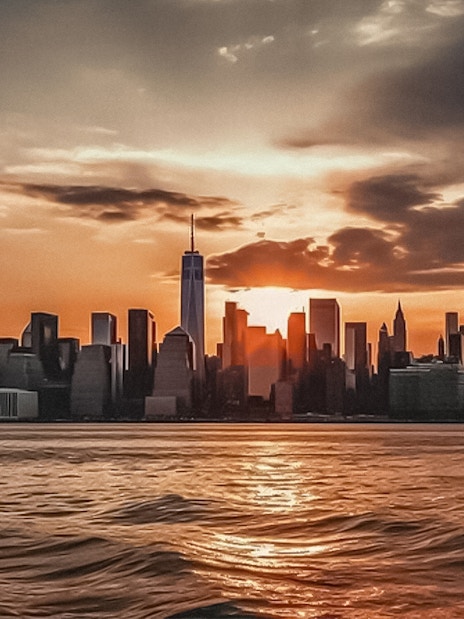New York City skyline at sunset from Ellis Island cruise.