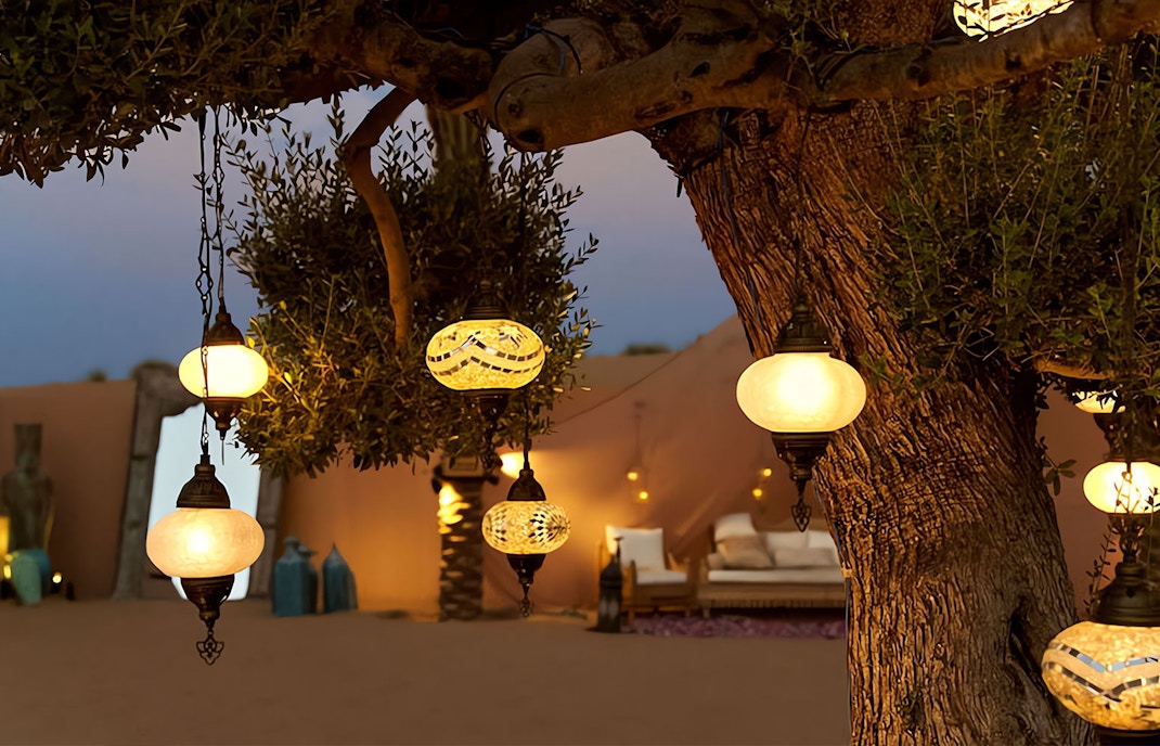 Lanterns cast a soft glow on traditional carpets, setting a magical tone for the evening