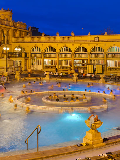 Outdoor thermal pool at Széchenyi Spa, Budapest, Hungary, with people enjoying the warm waters.